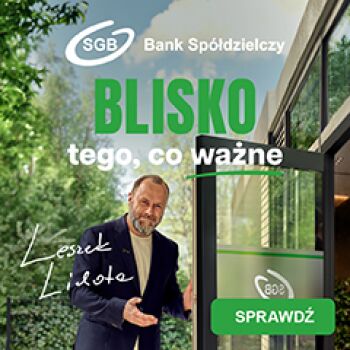 Aktor Leszek Lichota stojący przy drzwiach do oddziału z napisem SGB